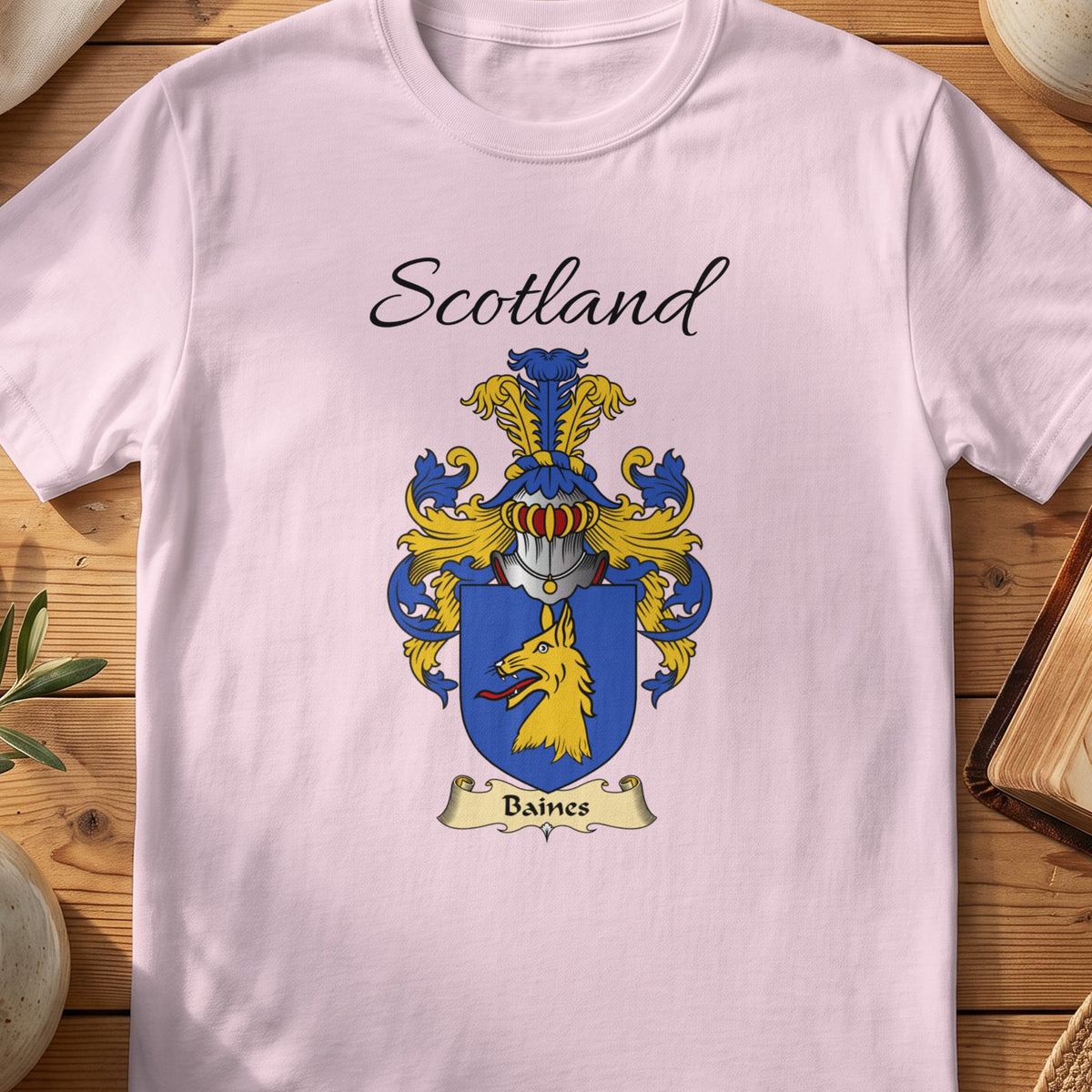 Light Pink Baines Scottish family shield T-shirt featuring a gold animal head on a blue shield