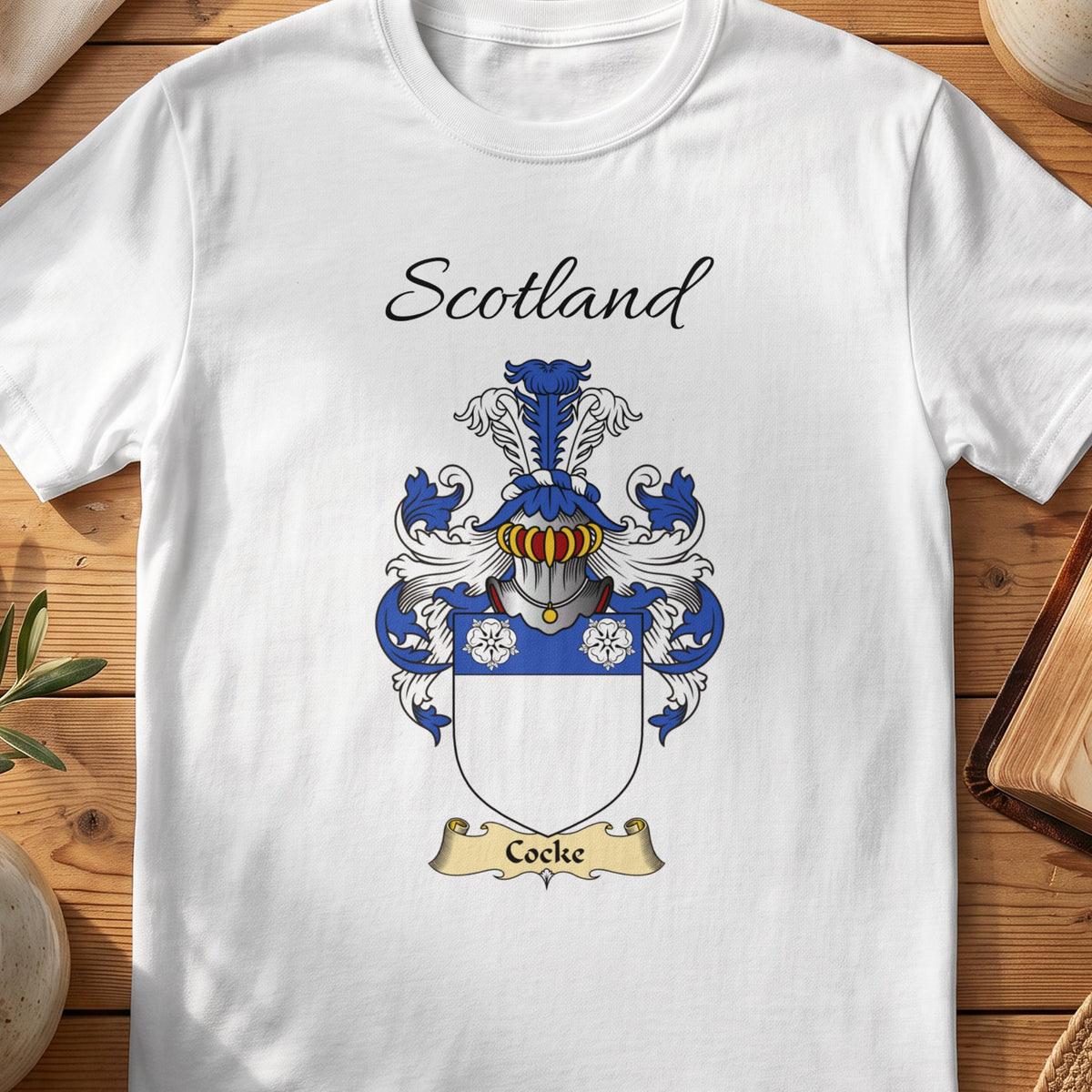White Cocke Scottish family shield T-shirt featuring three white flowers on a blue band