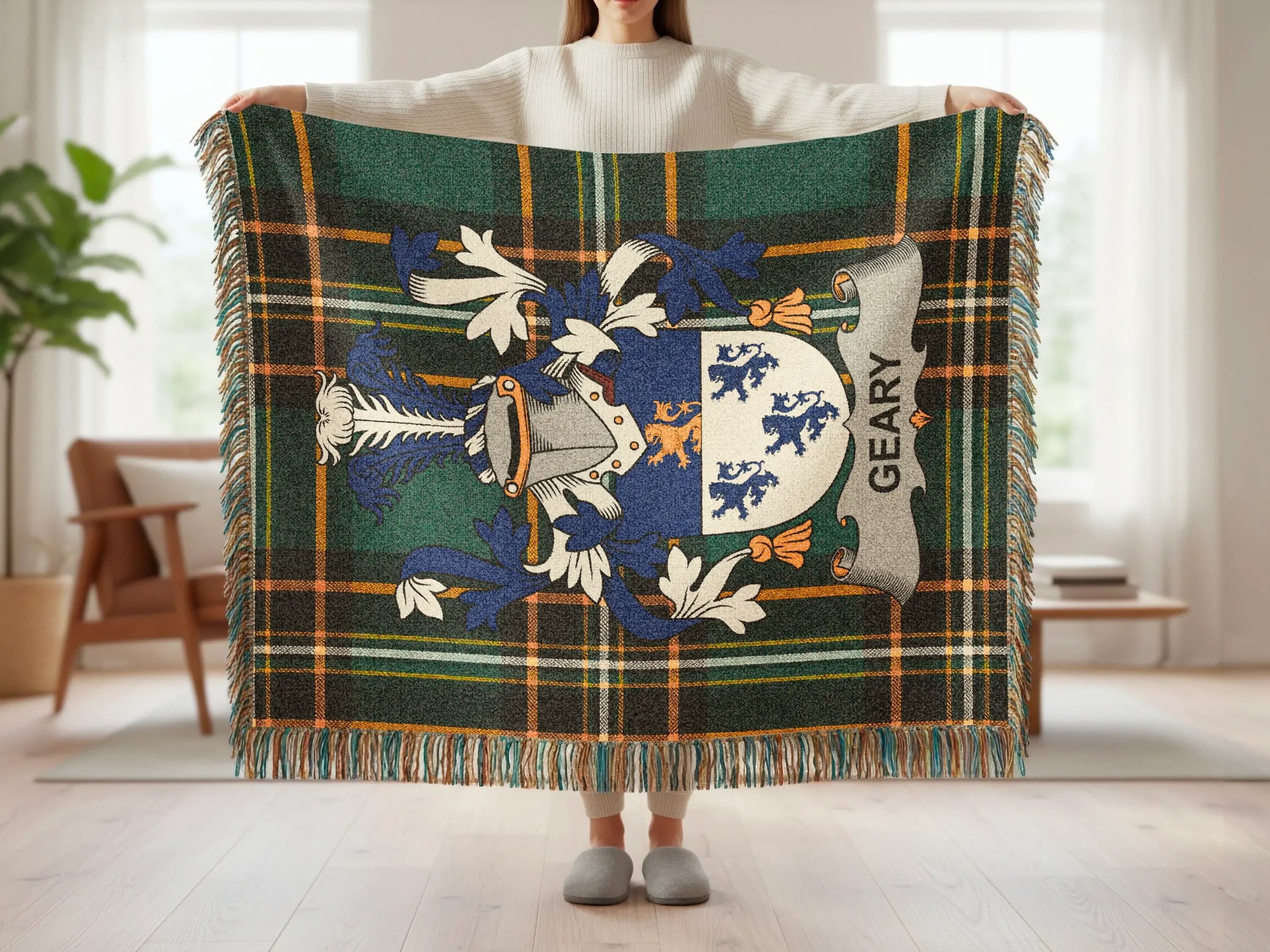 Tartan blanket with Geary family crest and fringe, held by person.