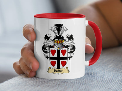 White mug with red handle, featuring a coat of arms with "Butter" nameplate.