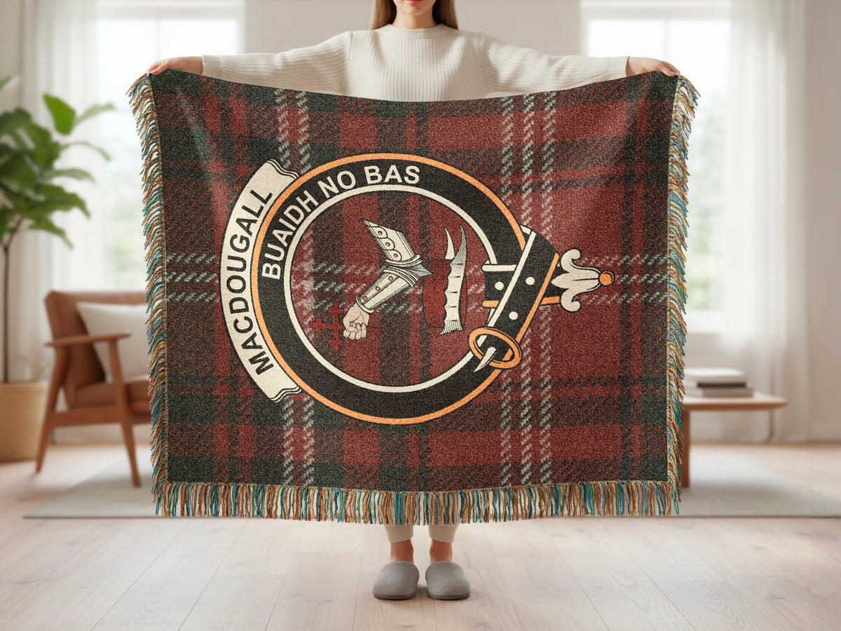 Person holding the MacDougall woven blanket to show the full design, tartan background and fringe