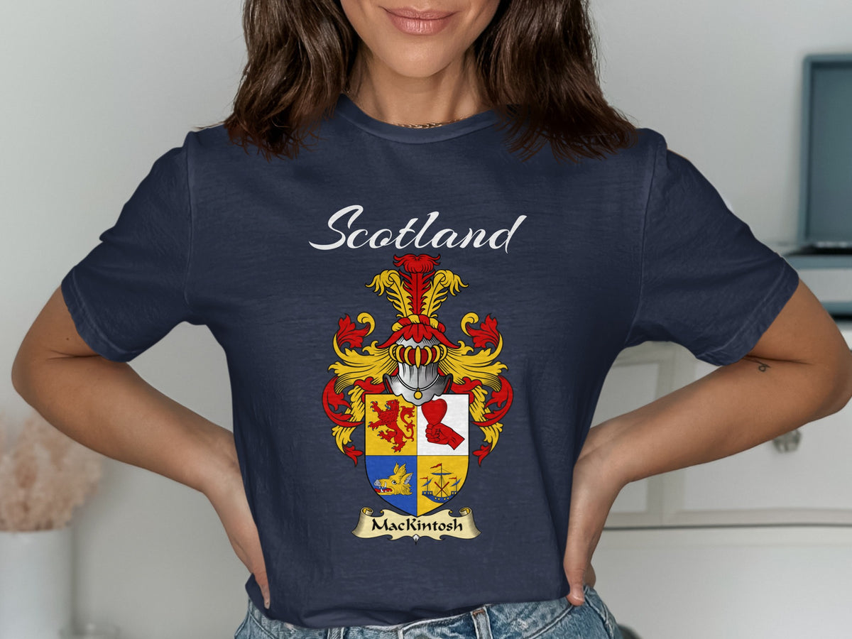 Model wearing a navy MacKintosh T-shirt featuring a quartered red, gold and blue shield