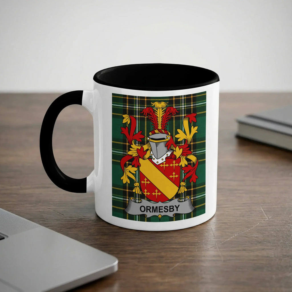 White mug with black rim and handle featuring the Ormsby coat of arms on a plaid background.