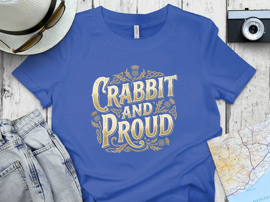 Blue t-shirt with "Crabbit and Proud" text in gold Celtic knotwork.