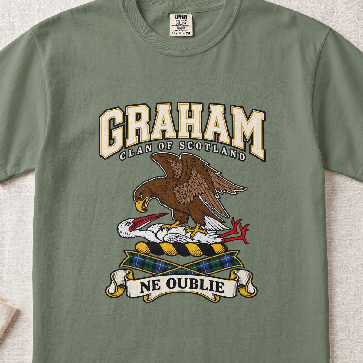 Graham graphic T-shirt in Moss green, front flat lay showing varsity lettering and brown eagle-like bird over a white long-necked bird with red beak and legs.