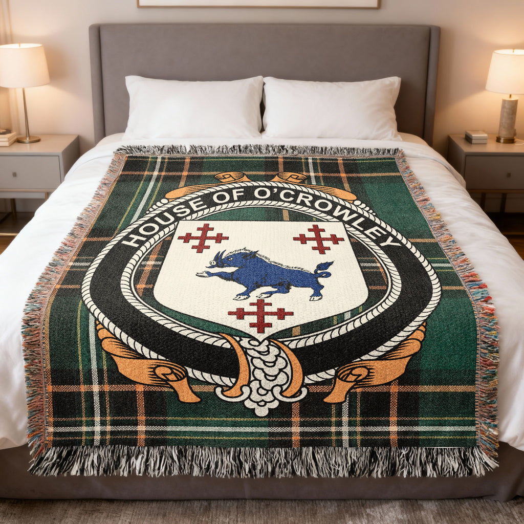 House of O'Crowley family crest woven blanket on an Irish National Tartan background, displayed on a bed
