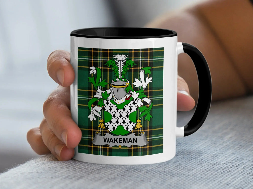 White mug with black rim featuring the Wakeman family crest on a green tartan background.