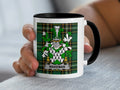 White mug with black rim featuring the Wakeman family crest on a green tartan background.