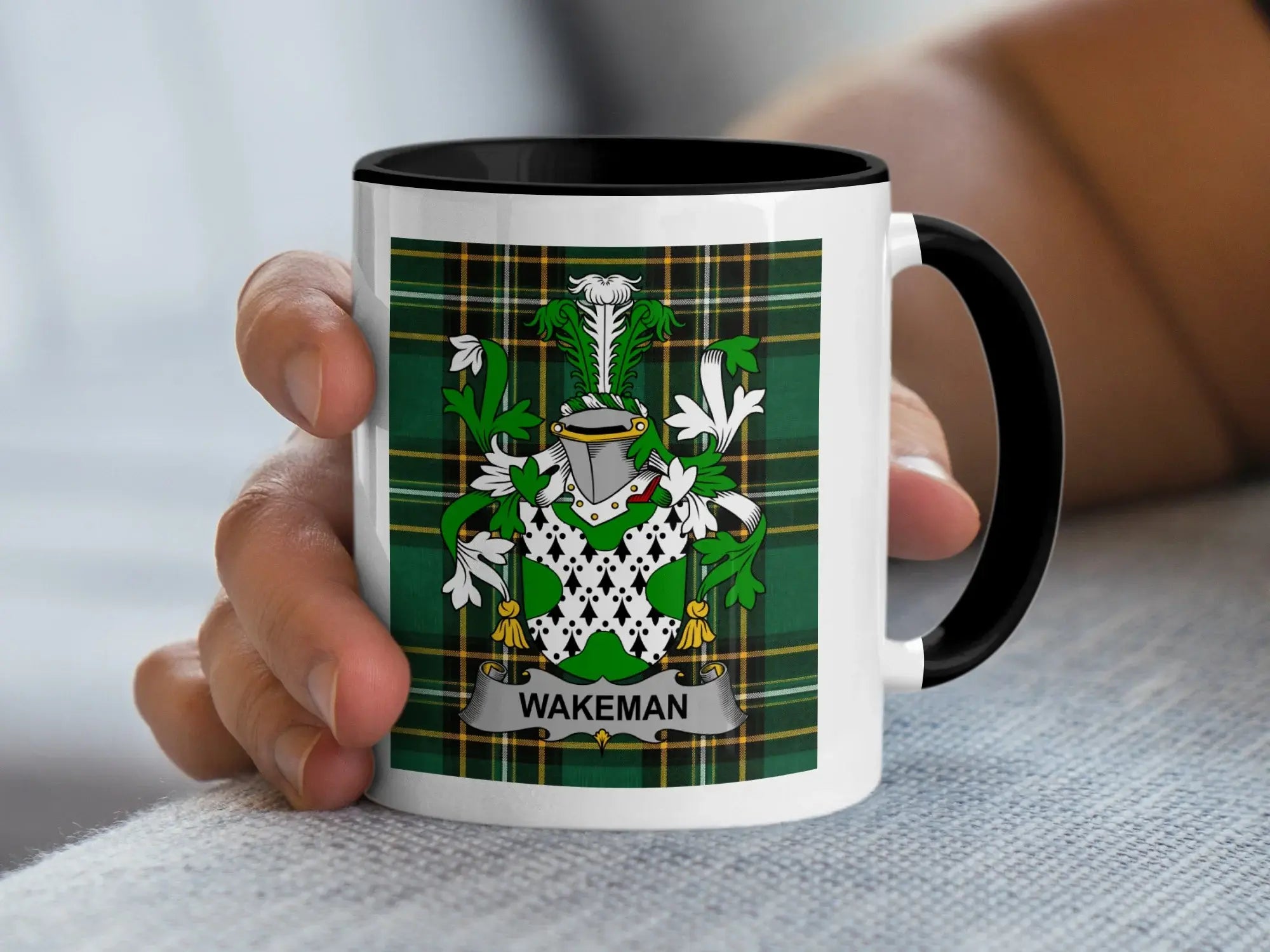 White mug with black rim featuring the Wakeman family crest on a green tartan background.