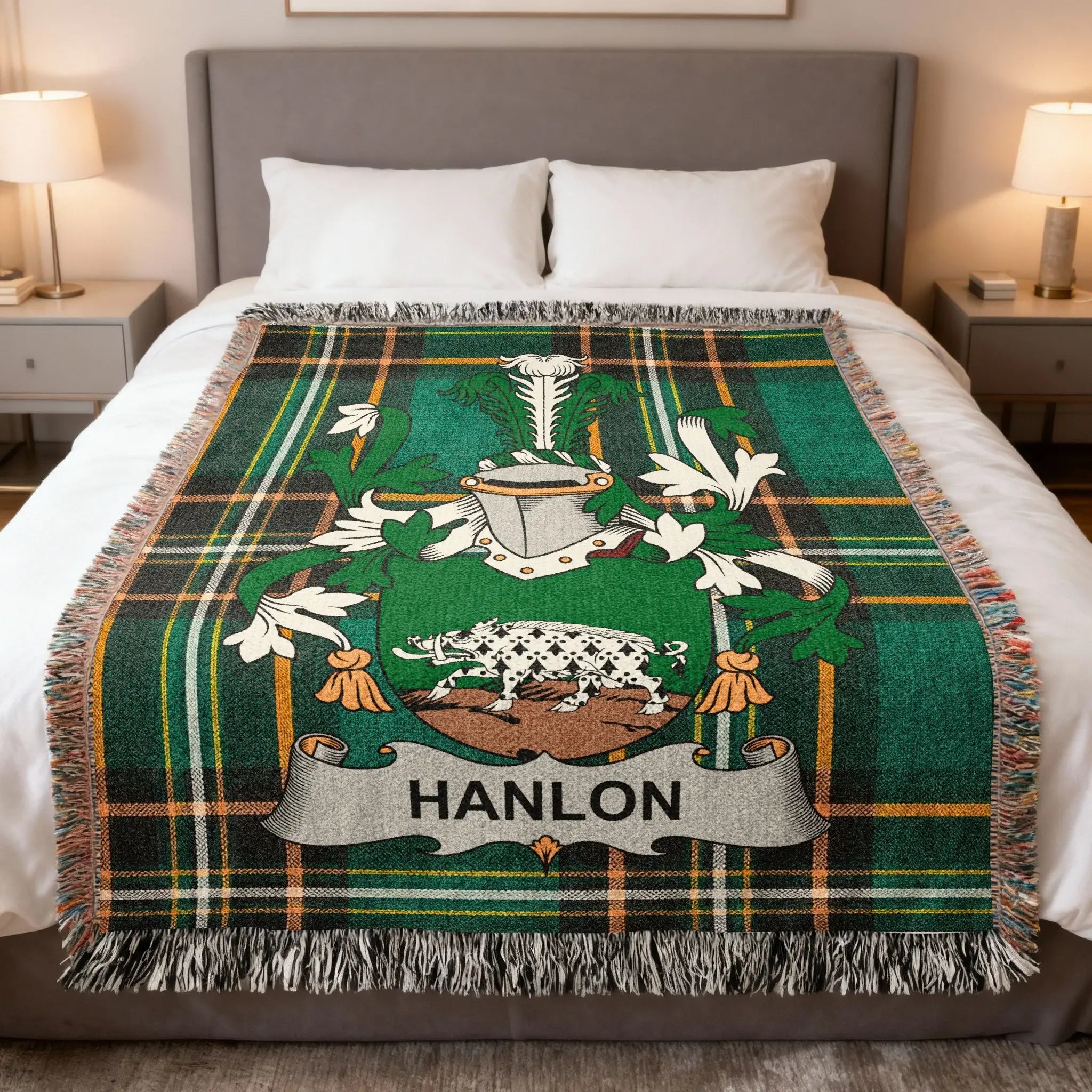 Green tartan blanket with Hanlon family crest centered on a bed.