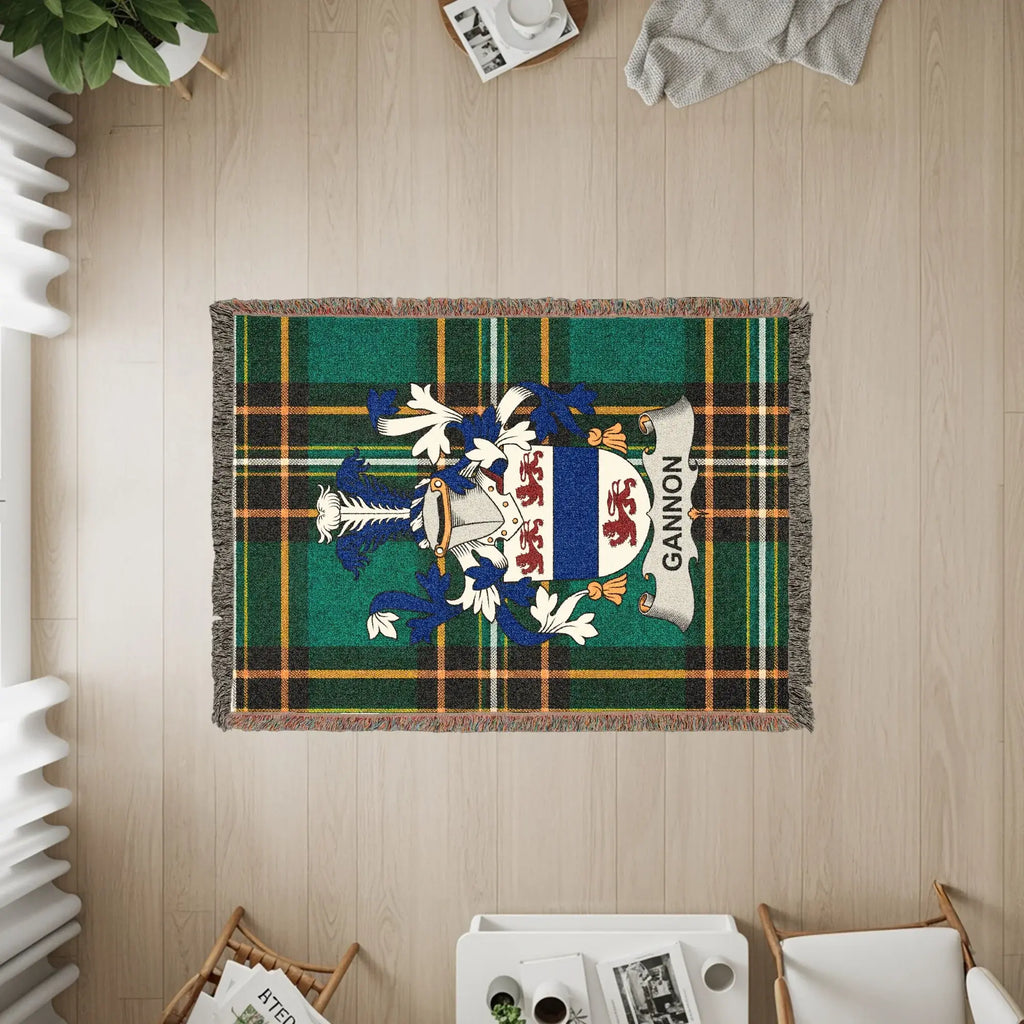 Woven blanket with Gannon family crest on plaid background.
