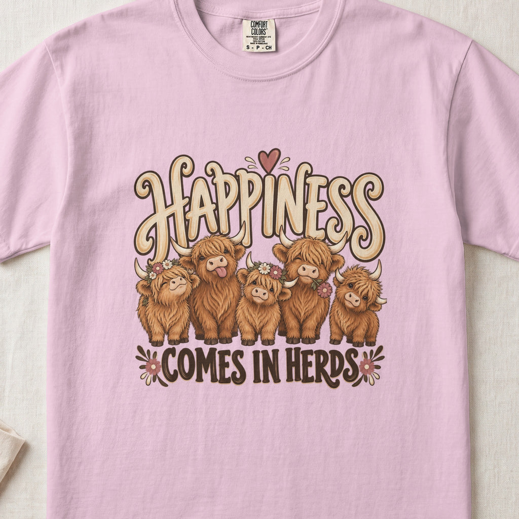 Happiness Comes in Herds Highland cow design on a Blossom Comfort Colors 1717 T-shirt, flat lay