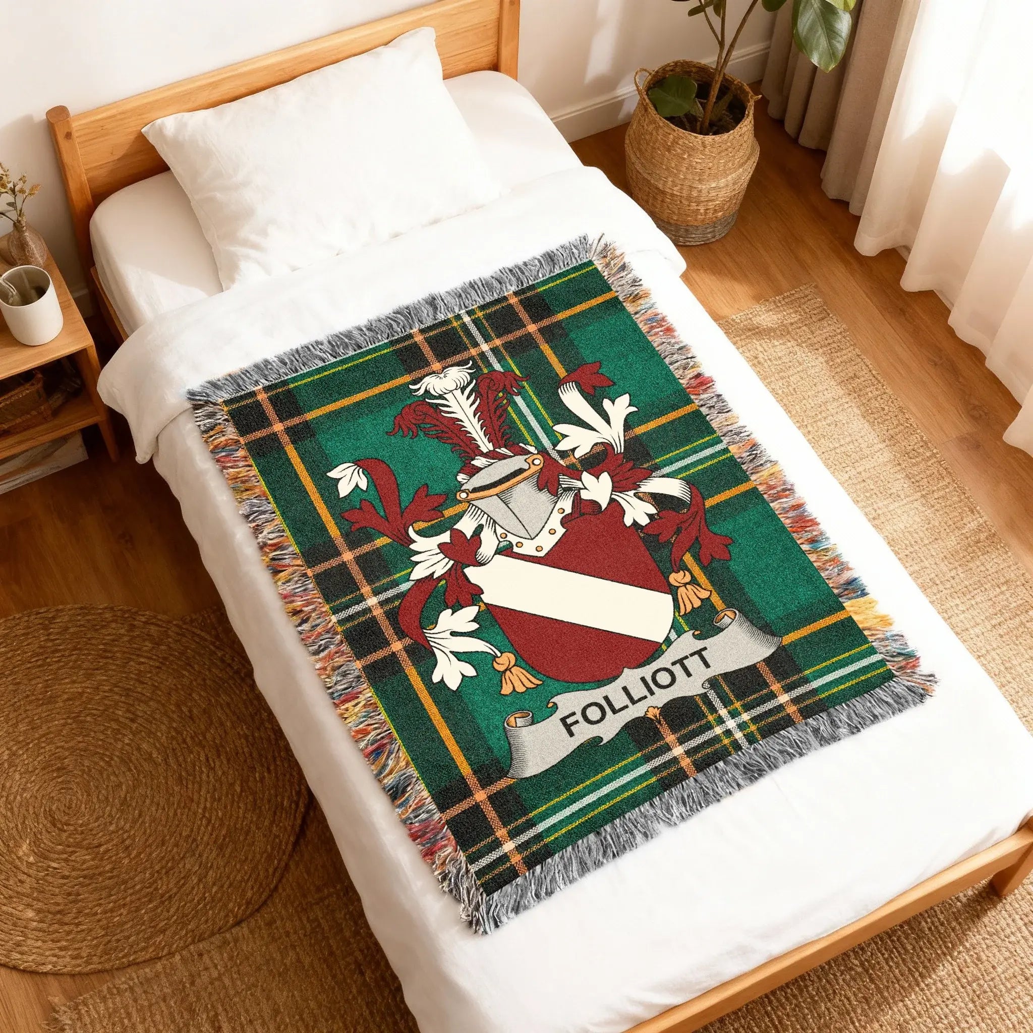 Foliott tartan crest blanket draped on a white duvet bed.