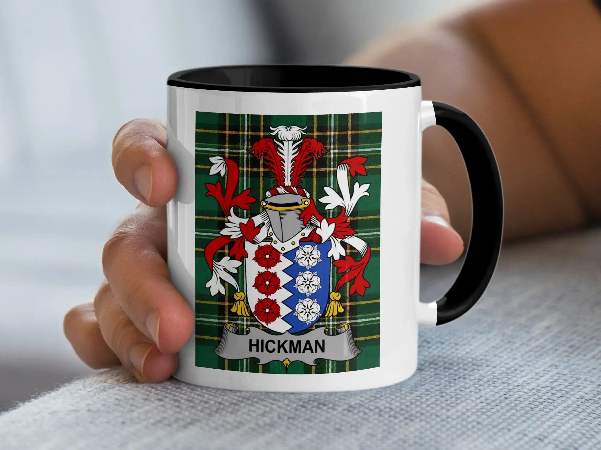 White mug with black handle featuring Hickman family crest on tartan background.