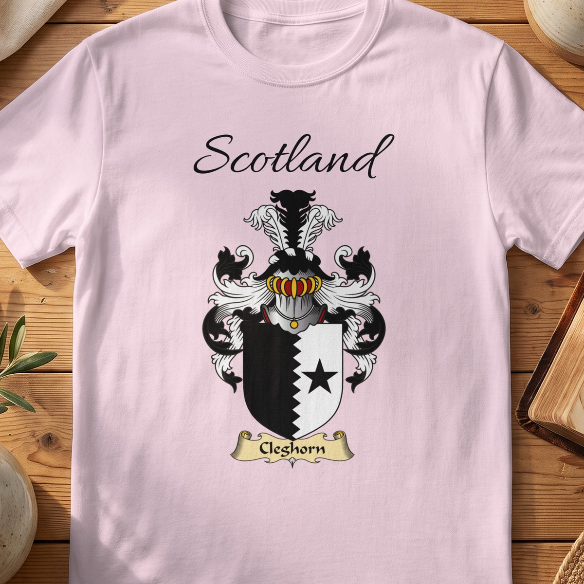 Light Pink Cleghorn Scottish family shield T-shirt featuring a black star beside a jagged black dividing line