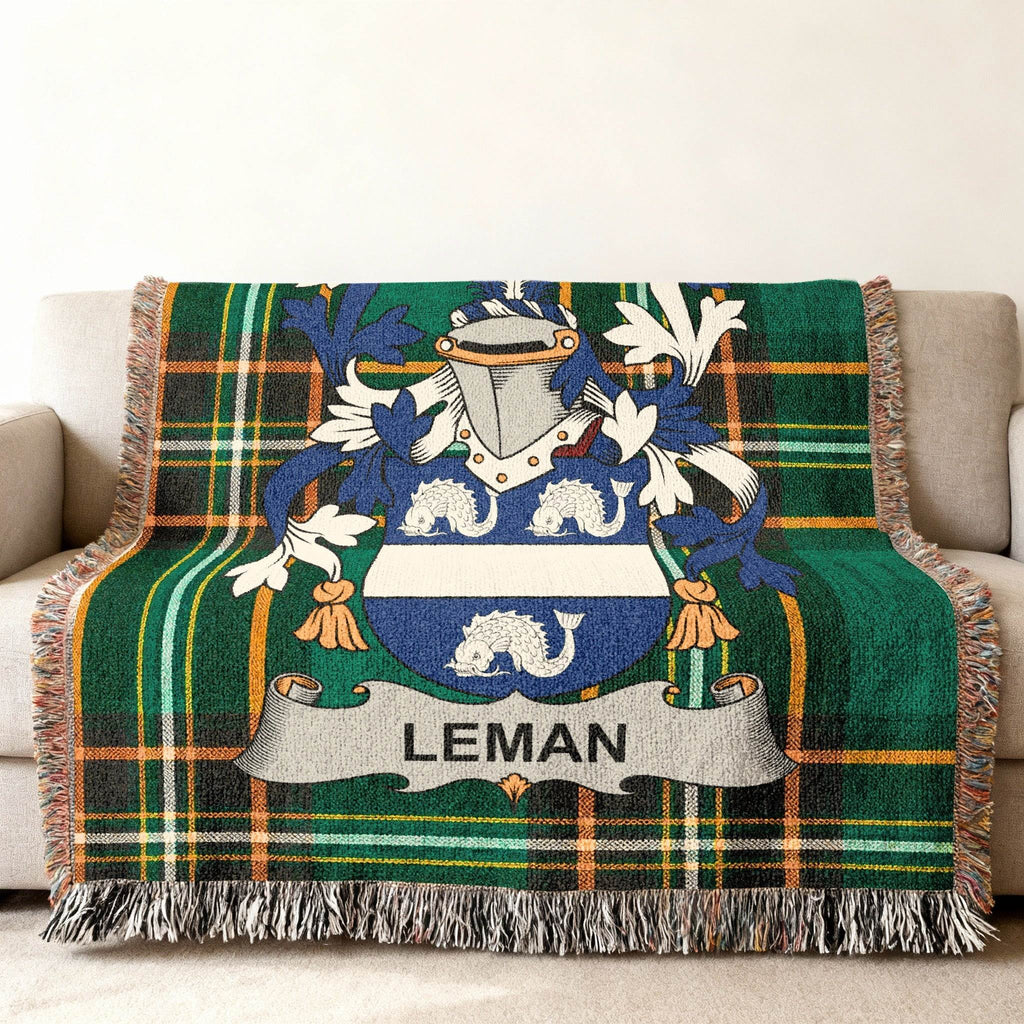 Green plaid throw blanket with Leman family crest and beige fringe.