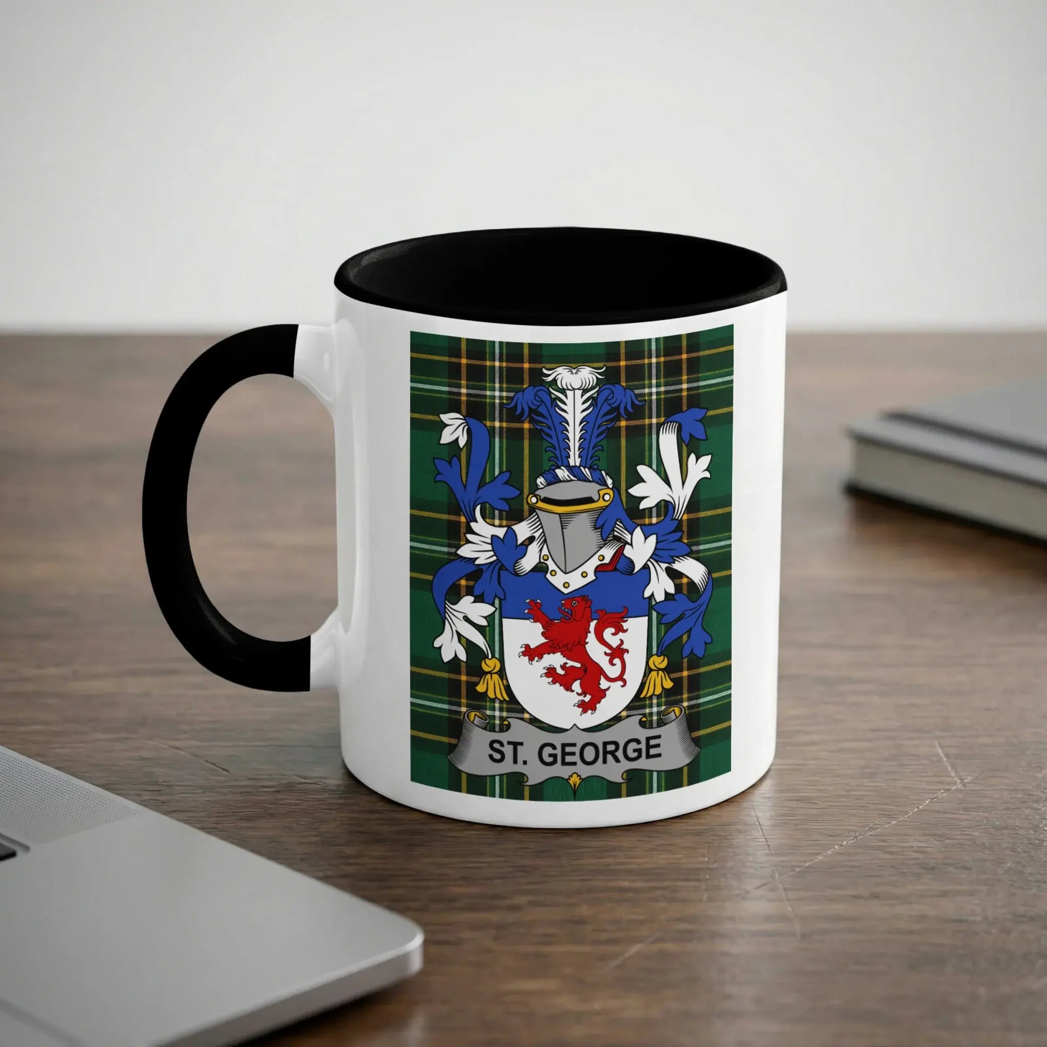 White mug with black rim displaying the St. George coat of arms and tartan pattern.