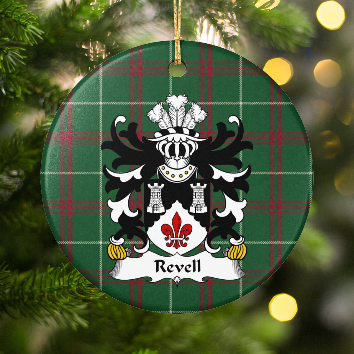 Revell Welsh National Tartan ornament hanging on a lit Christmas tree, featuring two silver towers above a red fleur-de-lis on a black and white shield.