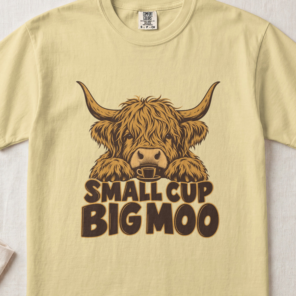 Small Cup, Big Moo Highland cow design on a Butter Comfort Colors 1717 T-shirt, flat lay