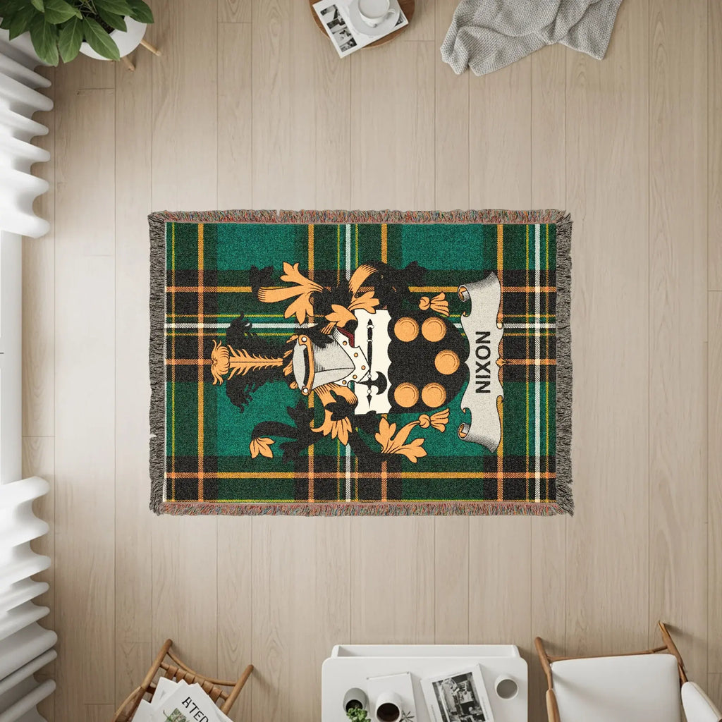 Woven blanket with Nixon family crest on green tartan plaid.