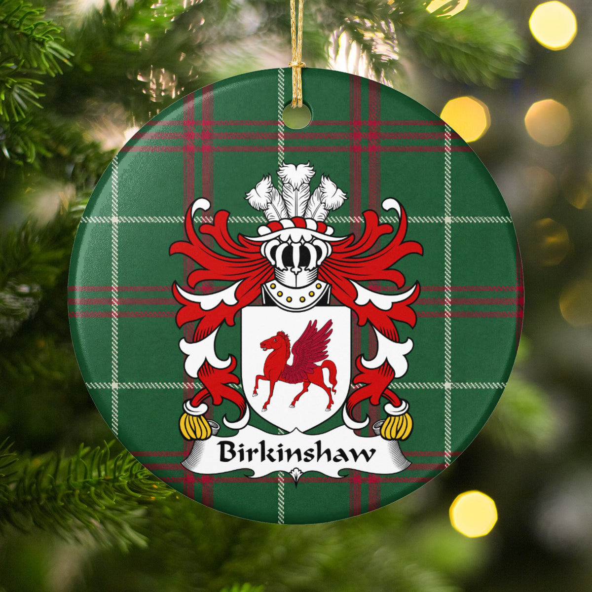 Birkinshaw ornament hanging in a Christmas tree with warm lights; a red winged horse on a white shield on Welsh national tartan.