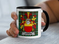 White mug with black rim featuring the Carron family crest on a plaid background.