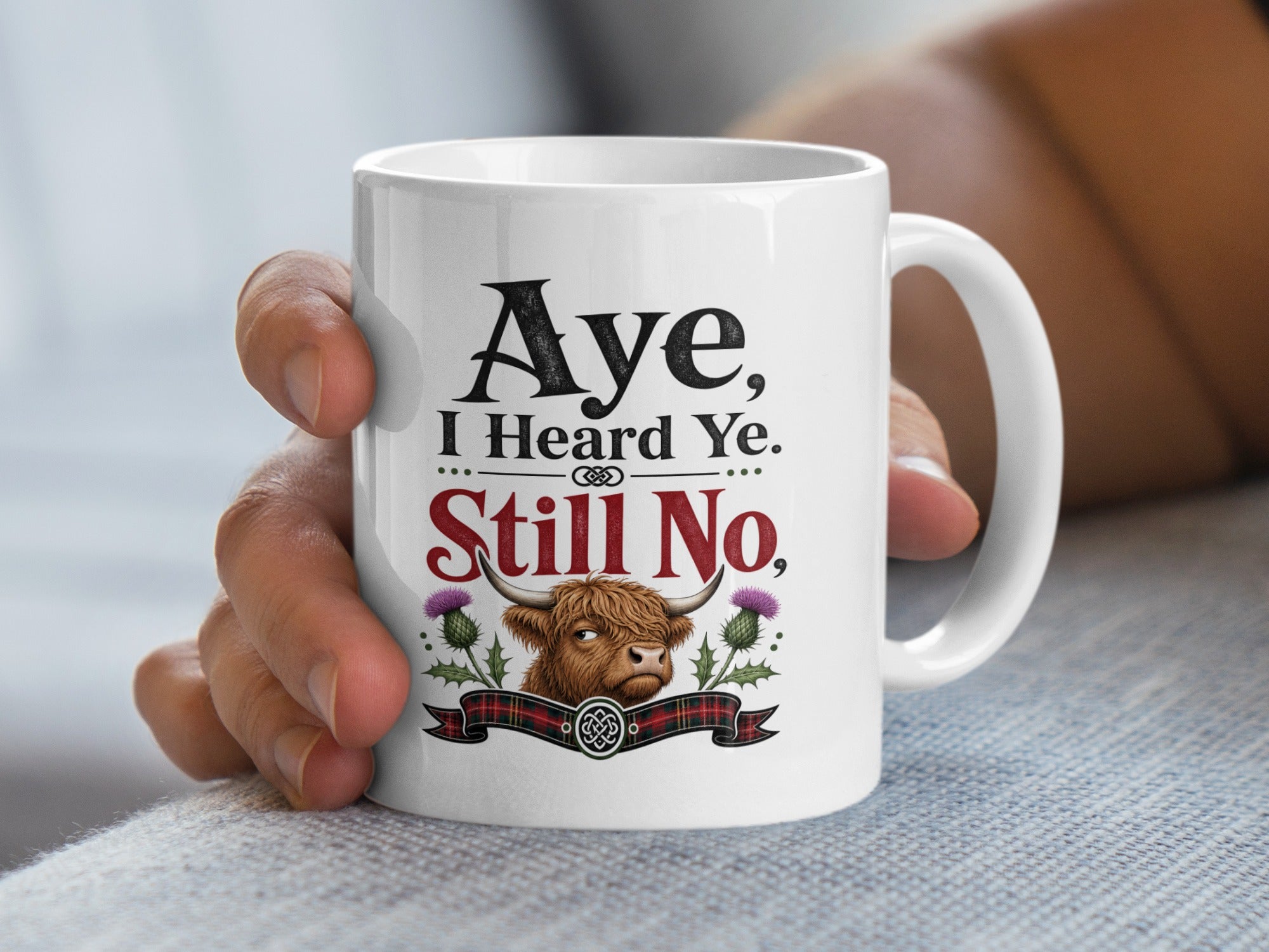 White mug with Highland cow illustration and "Aye, I Heard Ye. Still No." text.