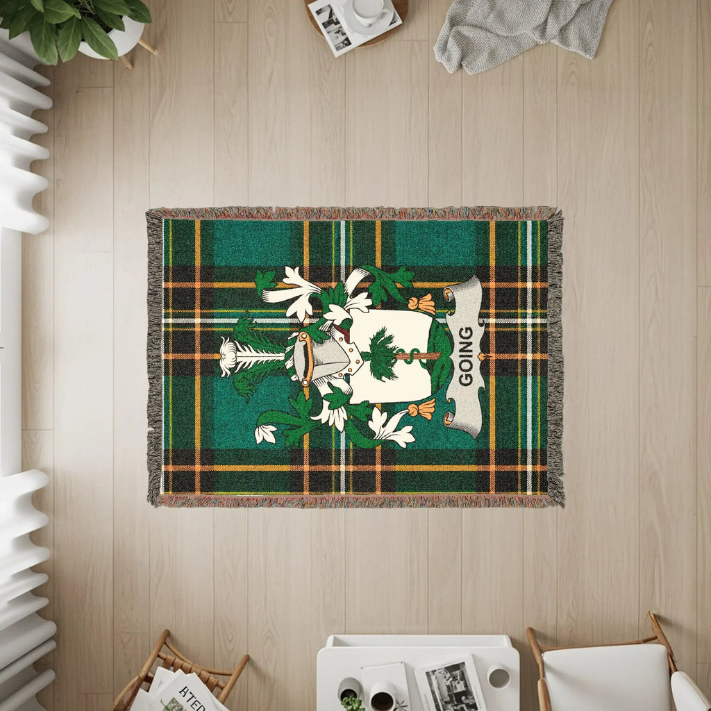 Tartan throw rug with a crest and the word "GOING" on a wooden floor.