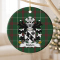 Rixton ceramic ornament with a black diagonal band with three silver covered cups between black fleurs-de-lis on Welsh National Tartan, hanging beside a window.