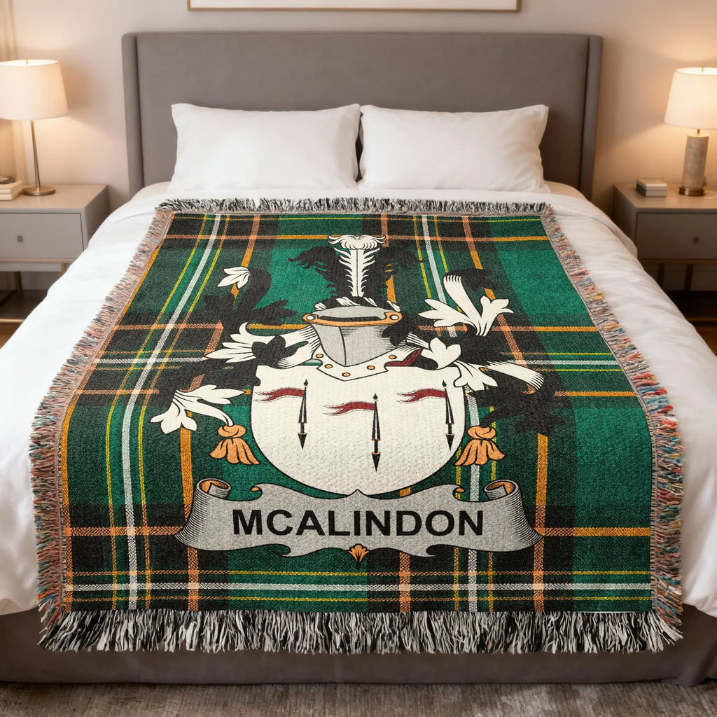 McAlindon tartan blanket with crest displayed on a bed.