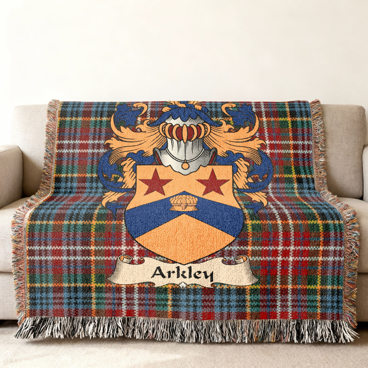 Arkley Scottish family shield woven blanket with Caledonia tartan background on a sofa