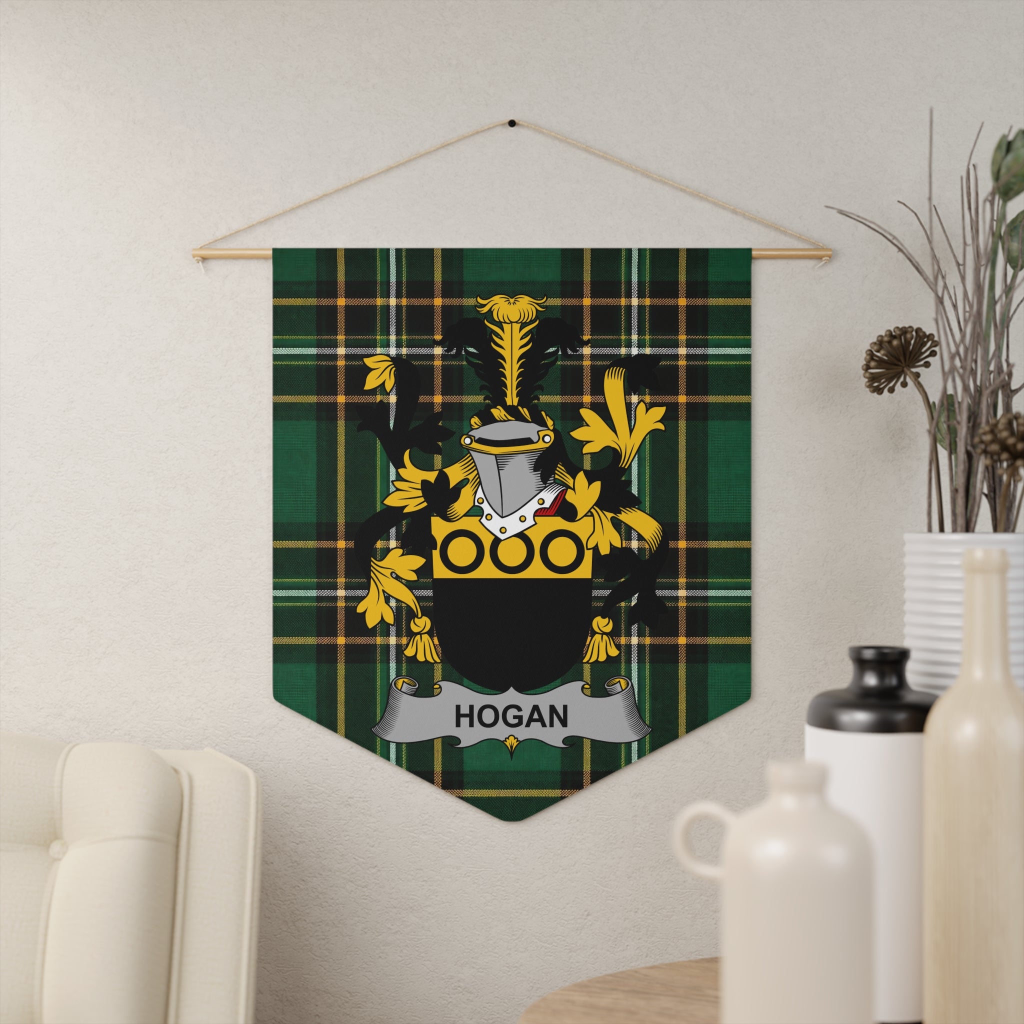 Hogan coat of arms on a green tartan pennant hanging on a textured wall.