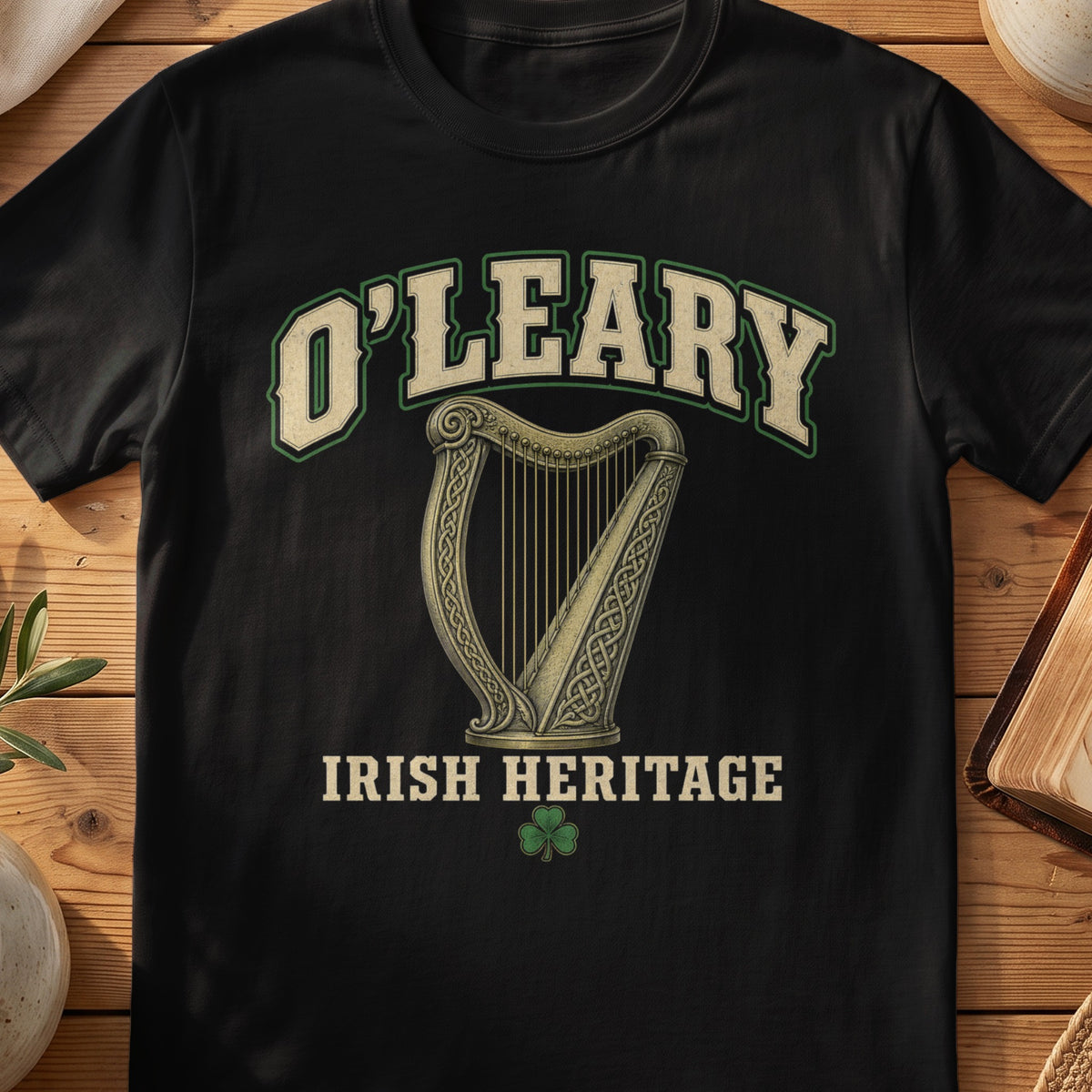 O'Leary Irish harp T-shirt in Black, with cream surname lettering, a gold-toned harp, green shamrock and “Irish Heritage” text.
