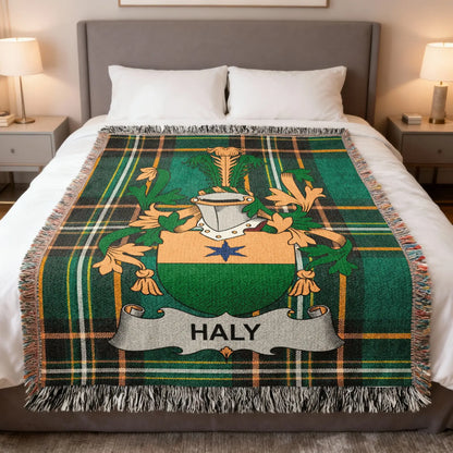 Tartan blanket with the Haly family crest centered on a bed.