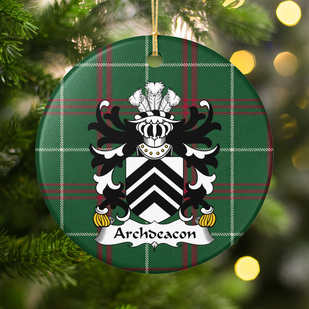 Archdeacon family crest and surname on a round Welsh national tartan ornament, hanging by a gold cord among Christmas tree branches and warm golden lights.