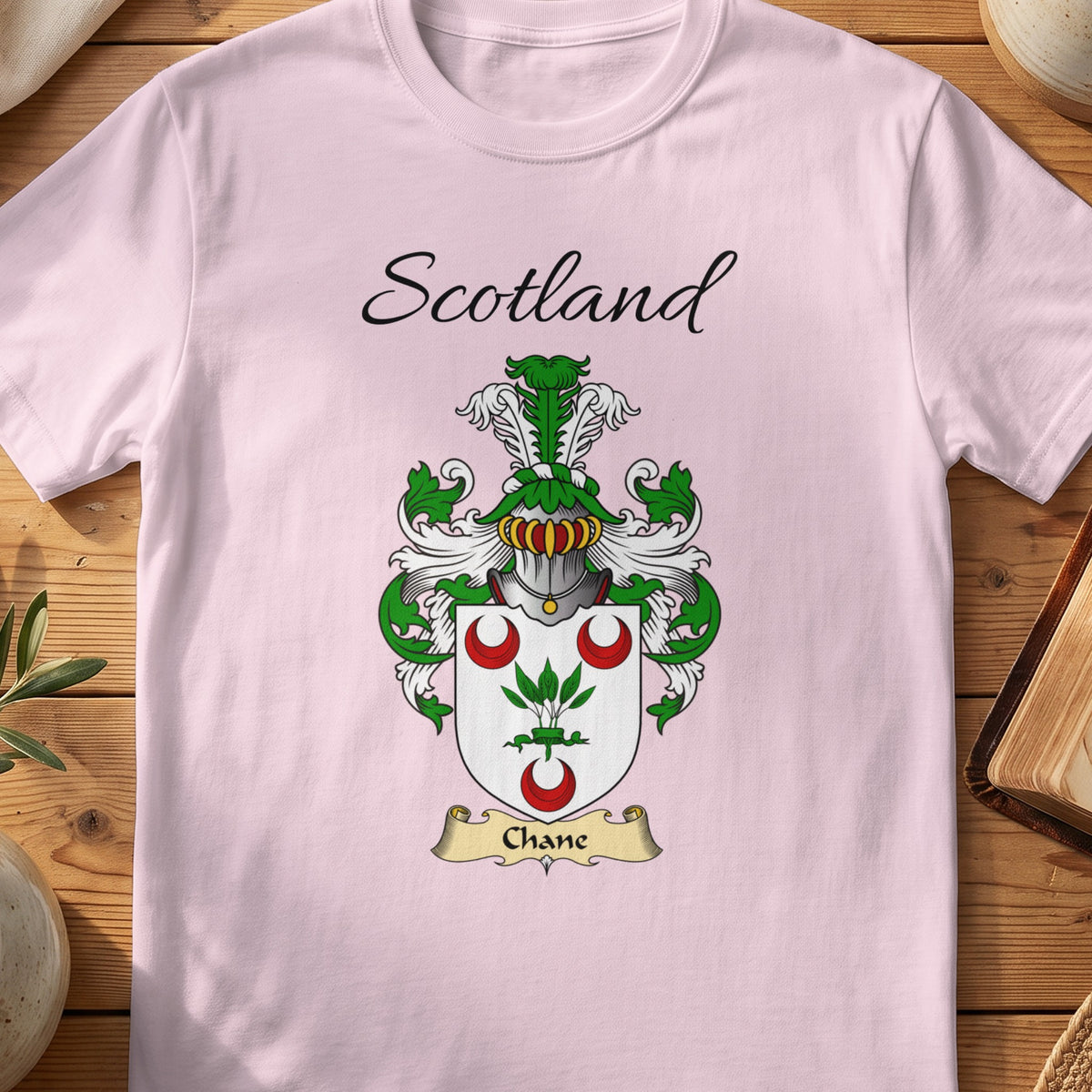 Light Pink Chane Scottish family shield T-shirt featuring a green plant between red crescents
