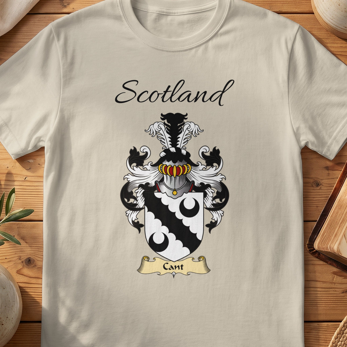 Sand Cant Scottish family shield T-shirt featuring a black scalloped diagonal band between black crescents