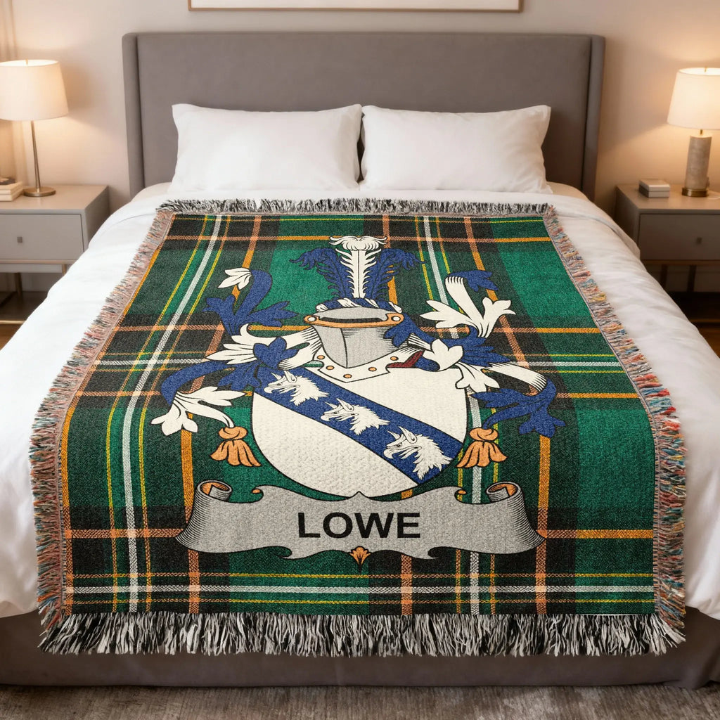 Green tartan blanket with Lowe family crest on a bed.