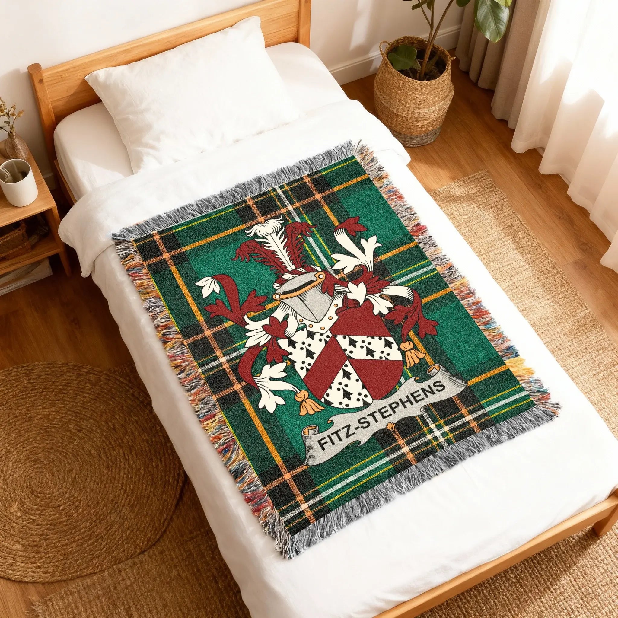 Green tartan blanket with Fitz-Stephens coat of arms on a bed.