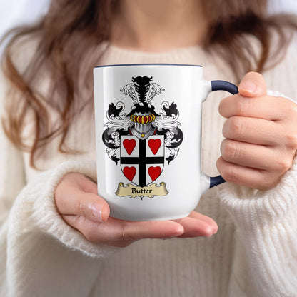 White mug with a black and red crest and "Butter" text.