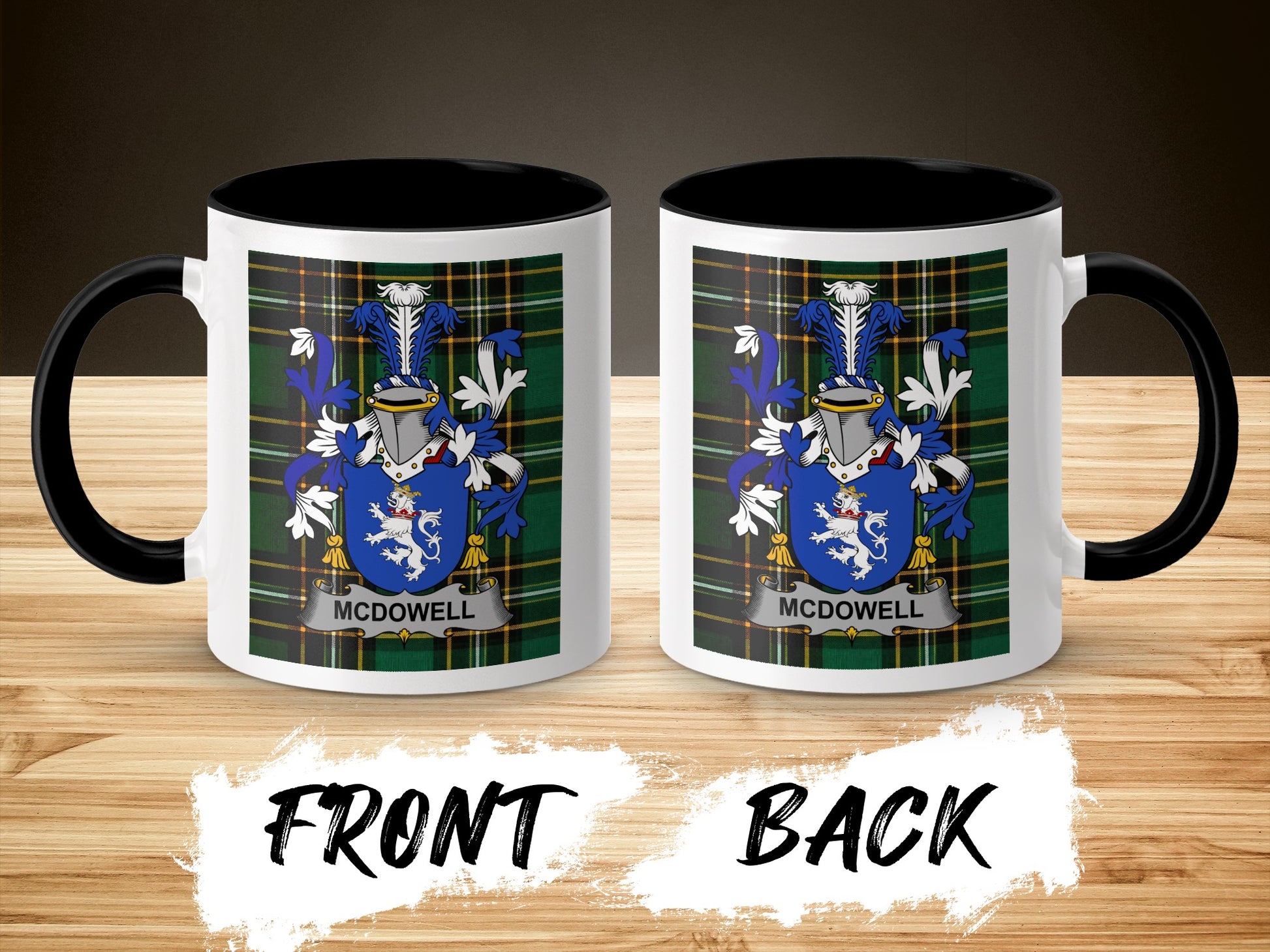 Two white mugs with black handles displaying a blue and white crest on a plaid background.