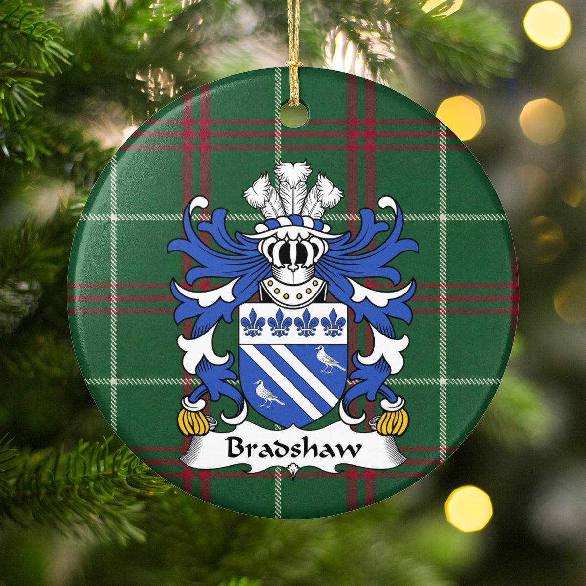 Bradshaw ornament hanging in a Christmas tree with warm lights; two white diagonal bands and two white birds on blue beneath four blue fleurs-de-lis on Welsh national tartan.