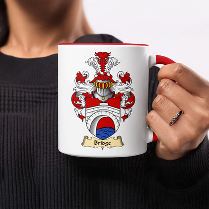 White mug with a red rim featuring a coat of arms with a bridge and the word "Bridge".