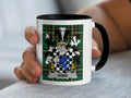 Mug with the HAND coat of arms on a tartan background.