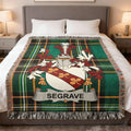 Seagrave family crest on a green tartan woven throw blanket on a bed.