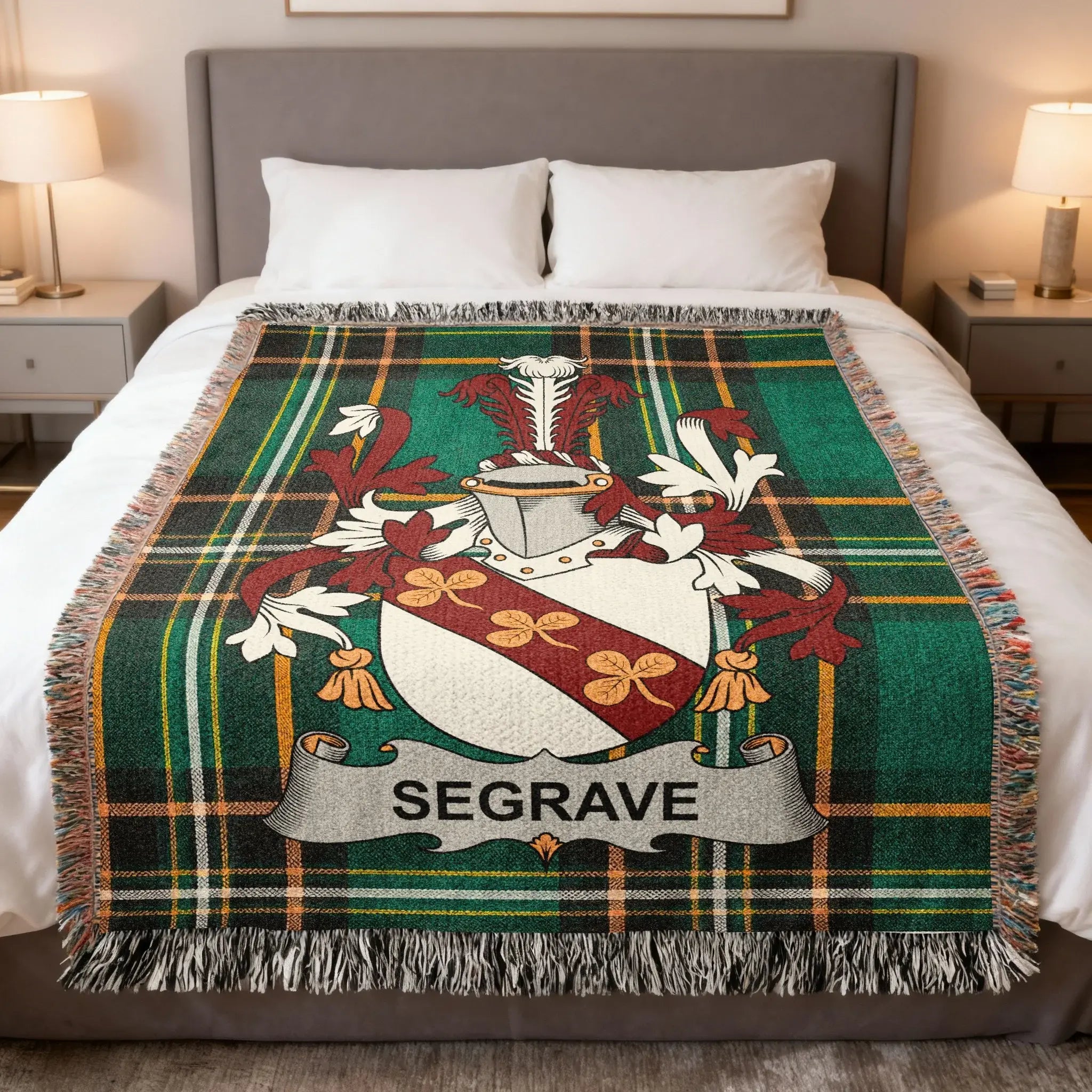 Seagrave family crest on a green tartan woven throw blanket on a bed.