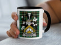 Mug with black handle and rim, featuring a green tartan pattern and the Roberts family crest.