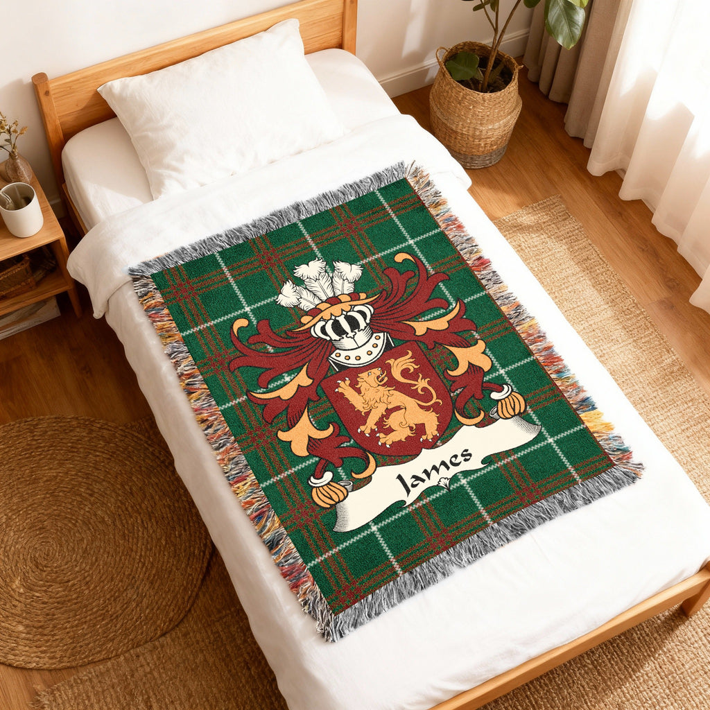 Woven blanket with a green plaid background and a family crest with the name "James".