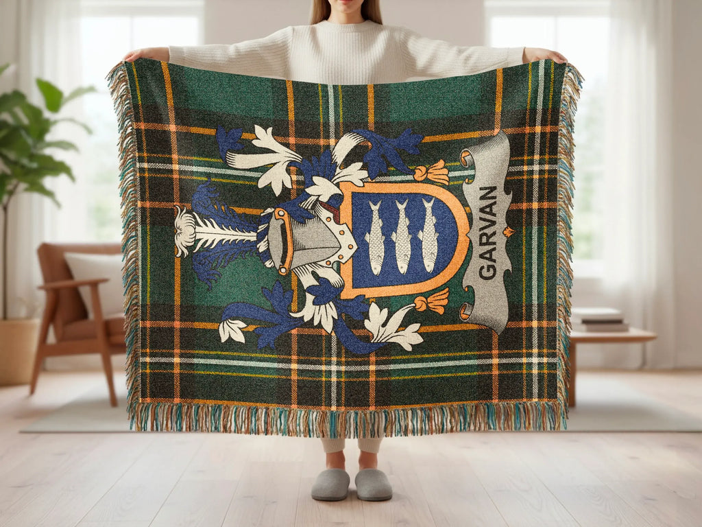 Plaid throw blanket with a crest featuring three fish and the name "Garvan".