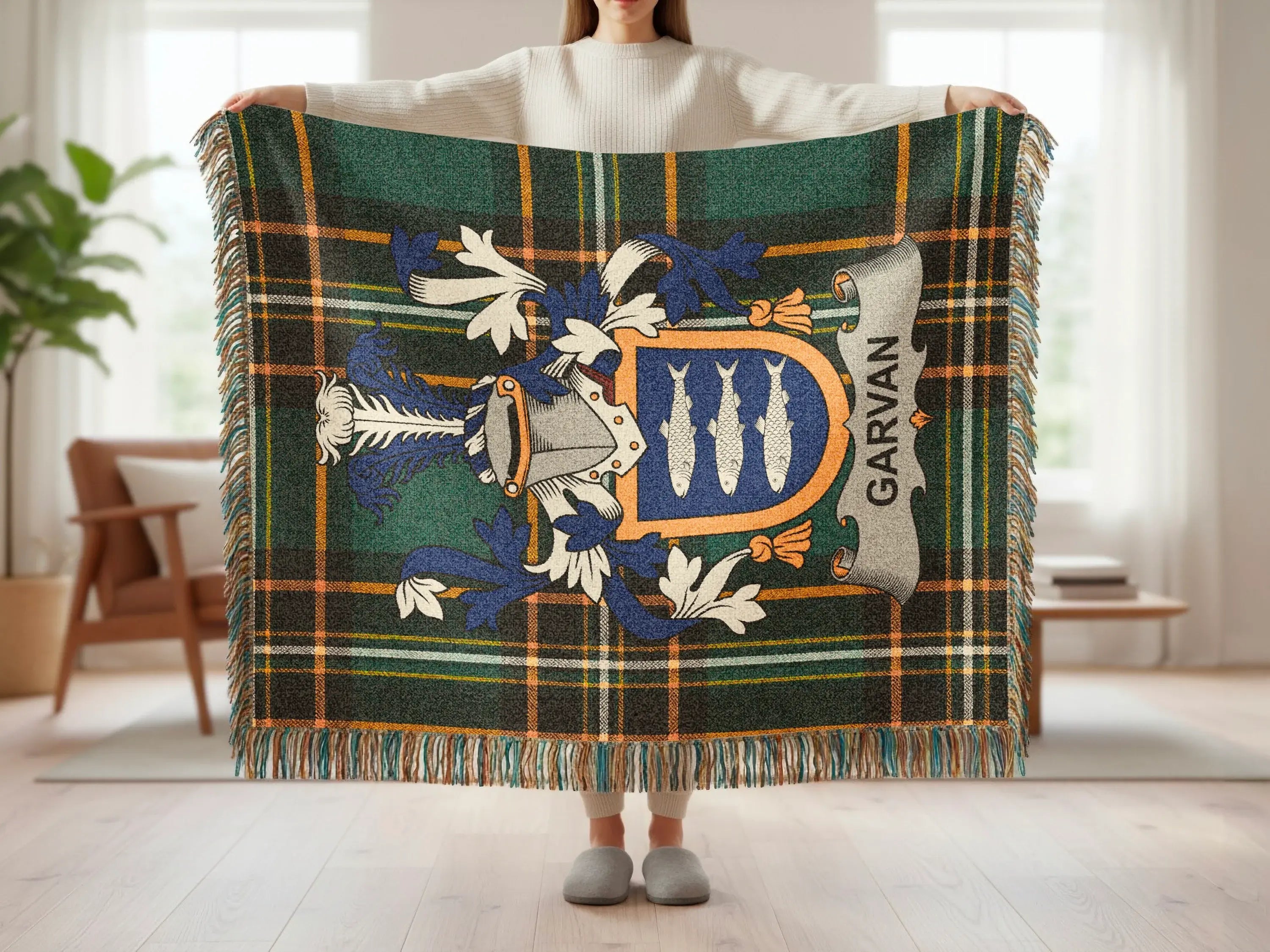 Plaid throw blanket with a crest featuring three fish and the name "Garvan".